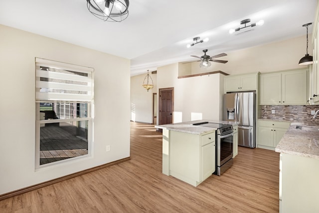 kitchen featuring light hardwood / wood-style floors, sink, hanging light fixtures, and appliances with stainless steel finishes