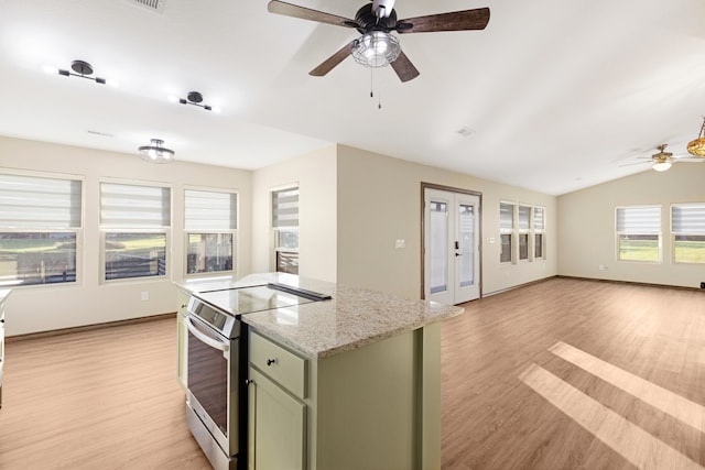 kitchen with light wood-type flooring, light stone counters, green cabinets, electric range, and lofted ceiling