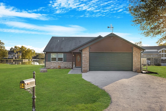 view of front of home featuring a front yard, a water view, and a garage