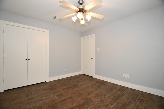 unfurnished bedroom featuring ceiling fan and a closet