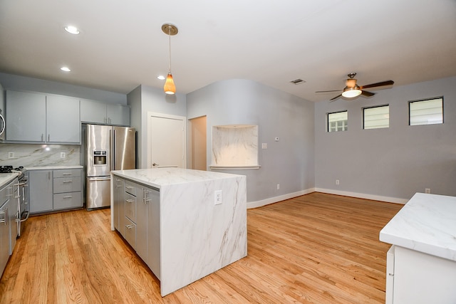 kitchen with pendant lighting, a center island, sink, light hardwood / wood-style floors, and stainless steel appliances