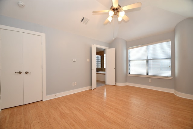 unfurnished bedroom with light wood-type flooring, ensuite bathroom, vaulted ceiling, and ceiling fan