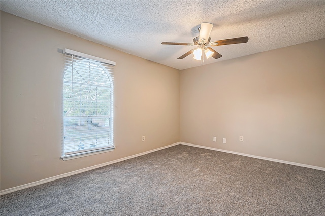 spare room with ceiling fan, dark carpet, and a textured ceiling