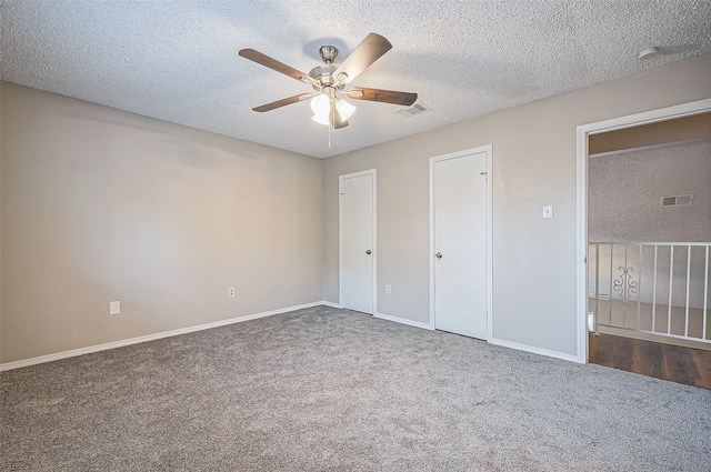 unfurnished bedroom featuring ceiling fan, carpet floors, and a textured ceiling