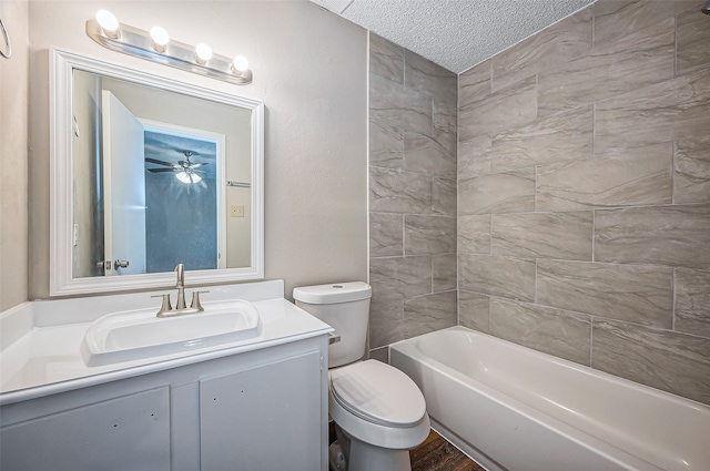 full bathroom featuring vanity, a textured ceiling, tiled shower / bath combo, ceiling fan, and toilet