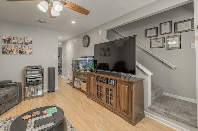 living room with light wood-type flooring and ceiling fan