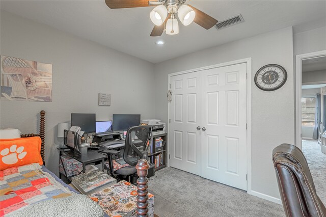 bedroom with ceiling fan, light colored carpet, and a closet