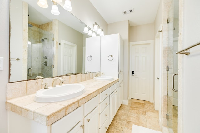 bathroom with vanity and a shower with shower door