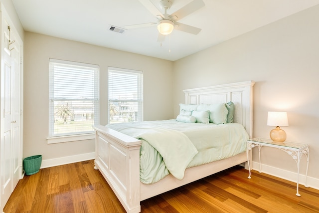 bedroom with ceiling fan, a closet, and wood-type flooring