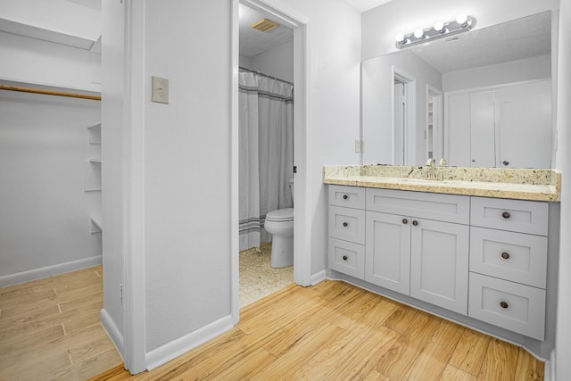 bathroom with a shower with curtain, vanity, toilet, and hardwood / wood-style floors