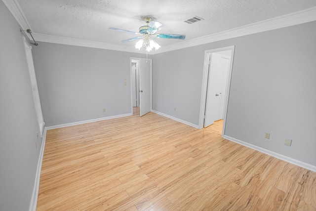 empty room featuring crown molding, light wood-type flooring, ceiling fan, and a textured ceiling