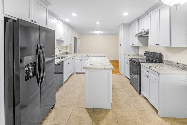 kitchen featuring sink, a center island, light stone counters, black appliances, and white cabinets