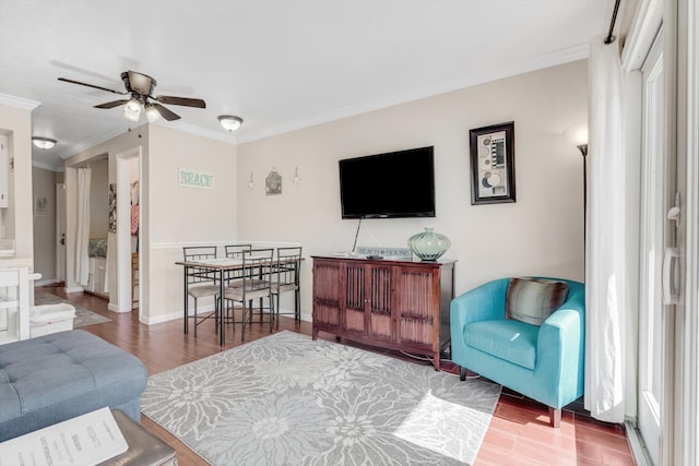 living room with hardwood / wood-style flooring, ceiling fan, and ornamental molding