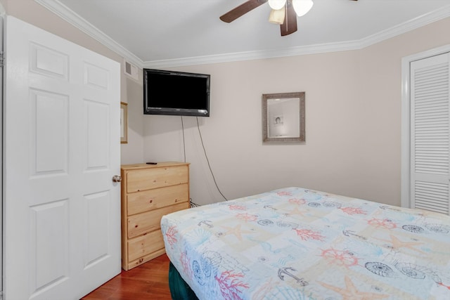 bedroom featuring dark hardwood / wood-style flooring, a closet, ceiling fan, and ornamental molding