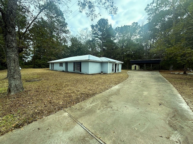 view of side of home with a carport and a lawn