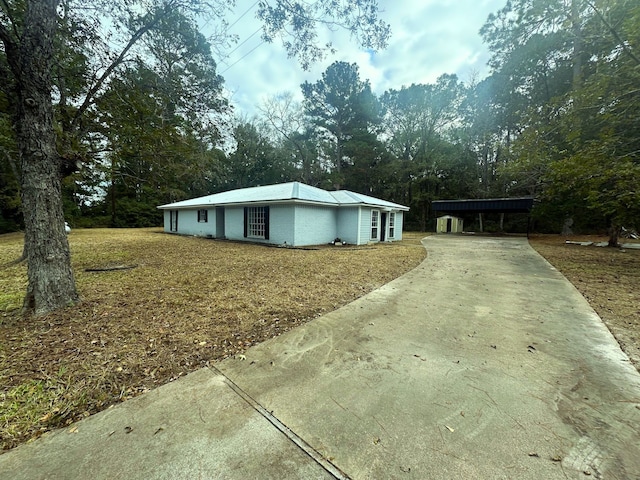 view of side of home with a carport and a lawn