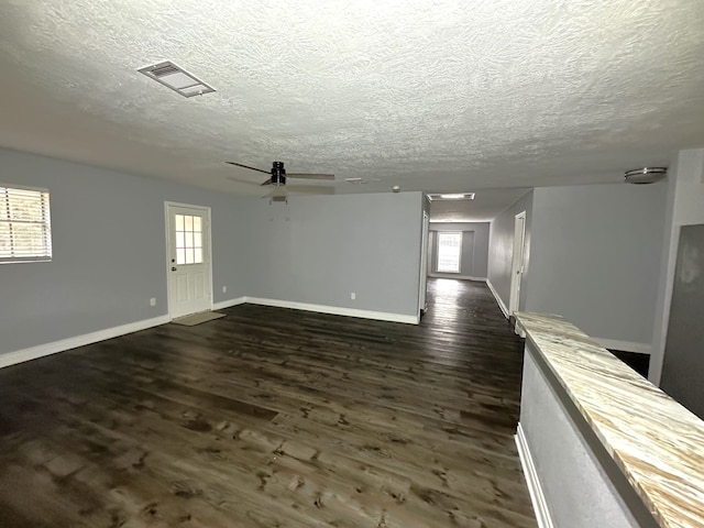 spare room featuring ceiling fan, dark hardwood / wood-style flooring, and a textured ceiling