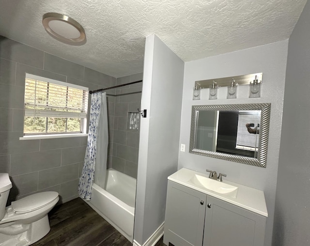 full bathroom with vanity, shower / bath combo, a textured ceiling, and hardwood / wood-style flooring