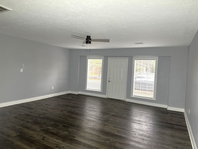 spare room with ceiling fan, plenty of natural light, and dark wood-type flooring