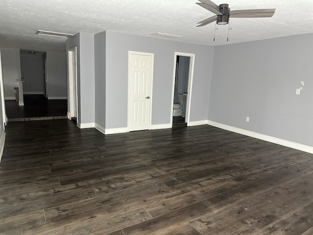 spare room featuring ceiling fan, dark wood-type flooring, and a textured ceiling