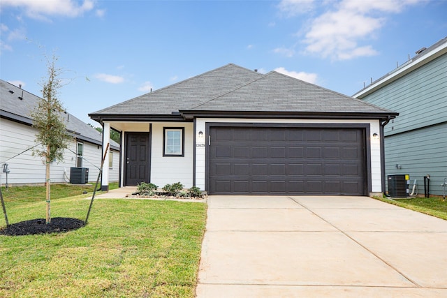 view of front facade with a garage, central air condition unit, and a front lawn