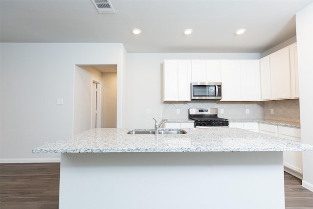 kitchen with white cabinetry, sink, appliances with stainless steel finishes, and an island with sink