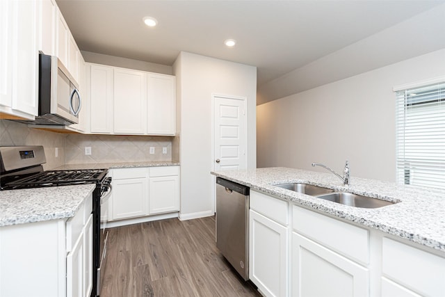 kitchen featuring tasteful backsplash, white cabinetry, sink, and appliances with stainless steel finishes