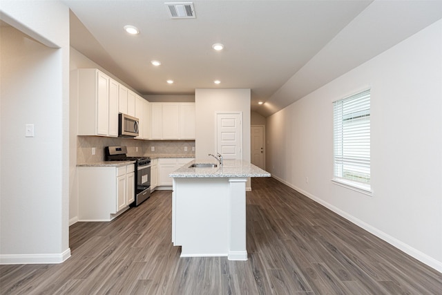 kitchen with white cabinetry, light stone countertops, sink, stainless steel appliances, and an island with sink