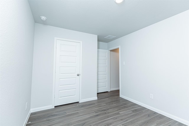 unfurnished bedroom with hardwood / wood-style flooring and a closet