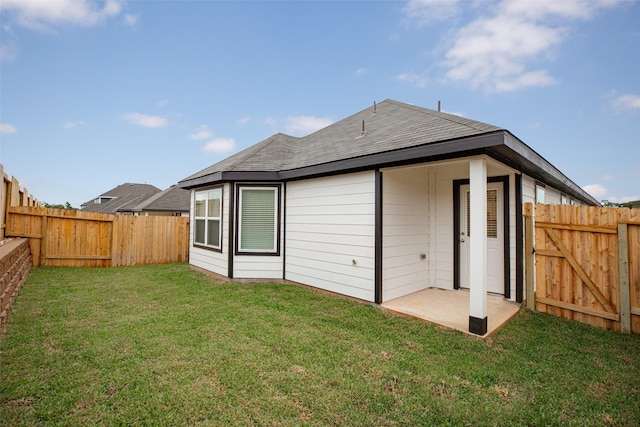 back of property with a lawn and a patio