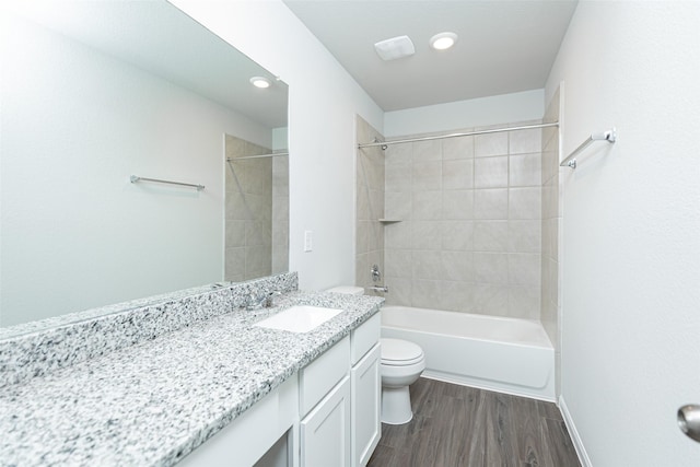 full bathroom with hardwood / wood-style flooring, vanity, toilet, and tiled shower / bath