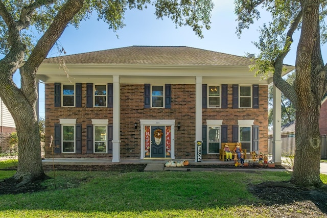 colonial inspired home featuring a front lawn