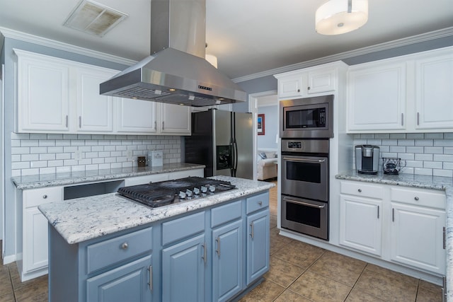 kitchen featuring backsplash, island range hood, stainless steel appliances, white cabinets, and a kitchen island