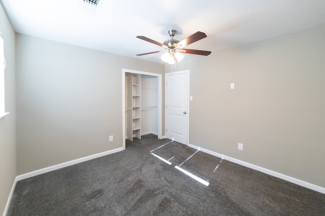 unfurnished bedroom featuring dark colored carpet, ceiling fan, and a closet