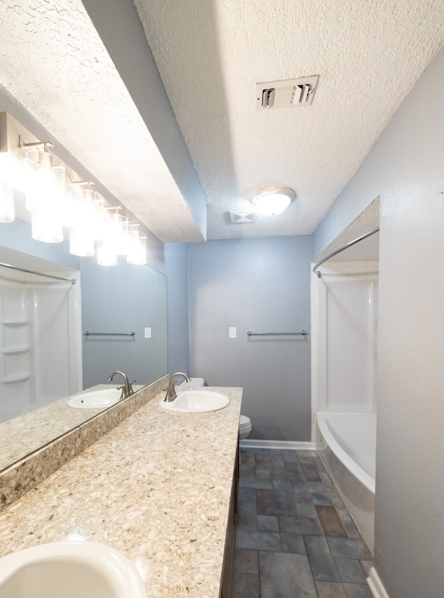 full bathroom with vanity, a textured ceiling, shower / bath combination, and toilet