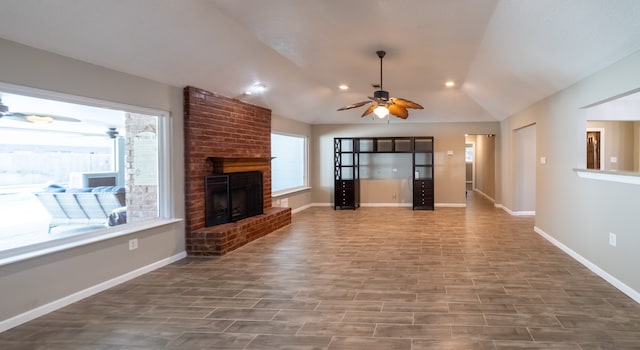 unfurnished living room with a brick fireplace, vaulted ceiling, and ceiling fan