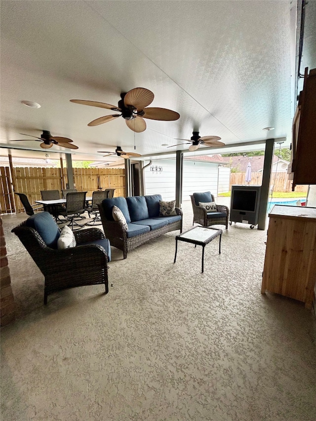 living room featuring ceiling fan, carpet floors, and a textured ceiling