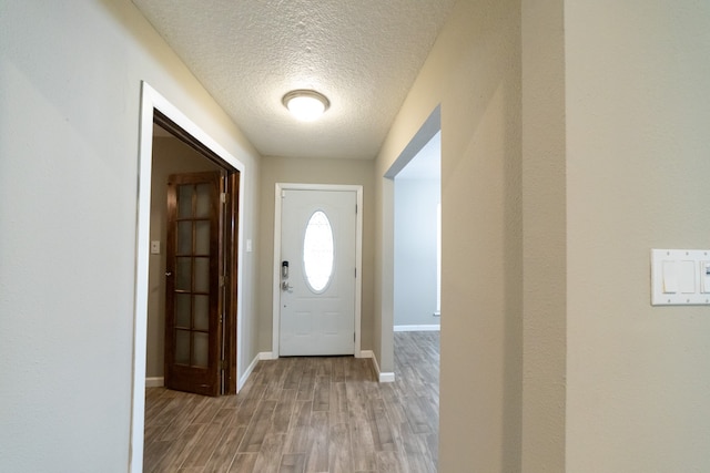 entryway featuring light wood-type flooring and a textured ceiling