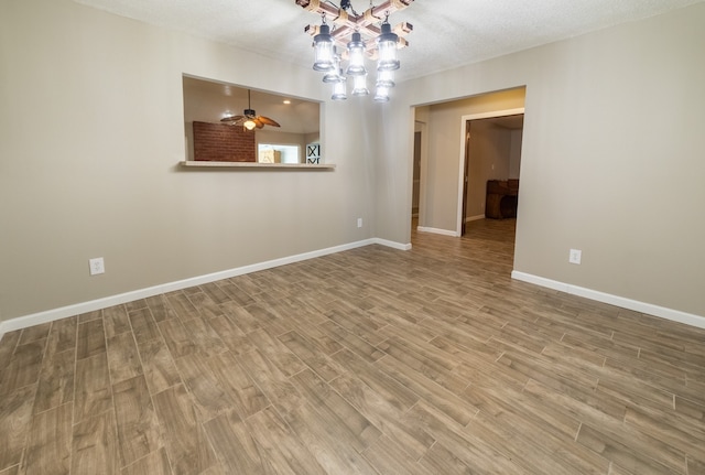 empty room with ceiling fan, a textured ceiling, and hardwood / wood-style flooring