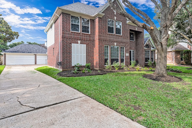 view of front of property with a front yard, a garage, and an outdoor structure