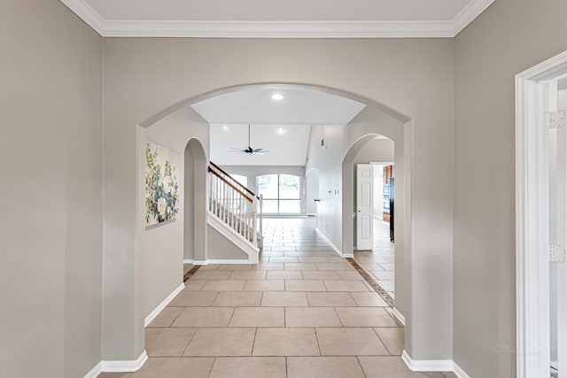 hall featuring light tile patterned floors and crown molding