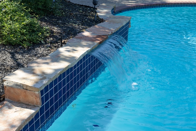 view of swimming pool with pool water feature