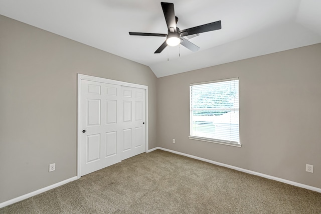 unfurnished bedroom with a closet, light colored carpet, ceiling fan, and lofted ceiling