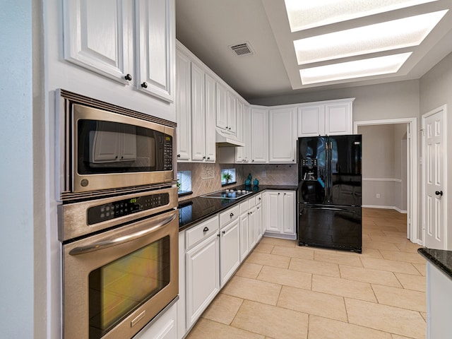 kitchen with black appliances, white cabinets, and backsplash