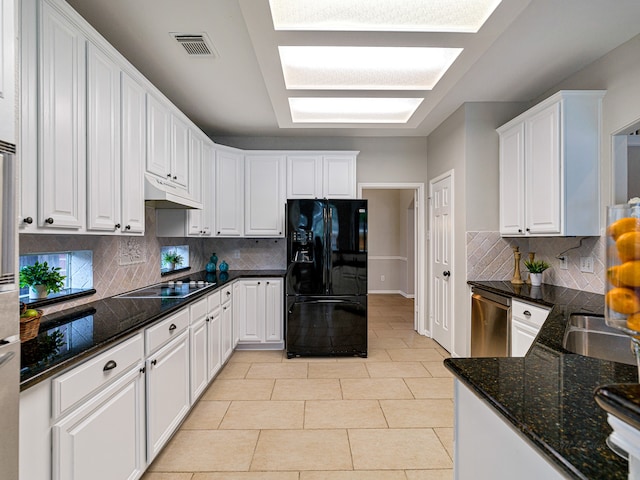 kitchen featuring white cabinets, decorative backsplash, and black appliances