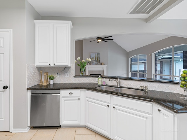 kitchen with dishwasher, sink, backsplash, vaulted ceiling, and white cabinets