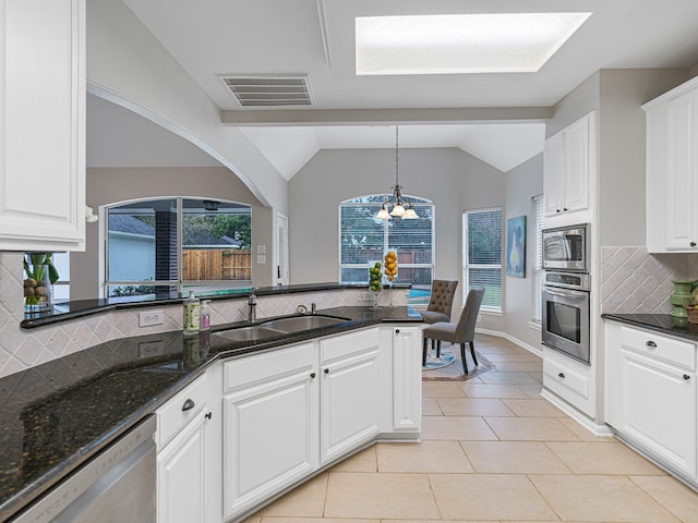 kitchen featuring white cabinets, stainless steel appliances, vaulted ceiling, and sink