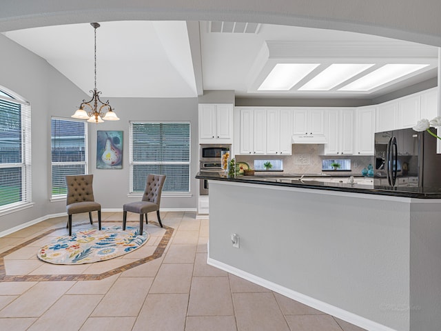 kitchen with white cabinets, lofted ceiling, stainless steel appliances, and an inviting chandelier