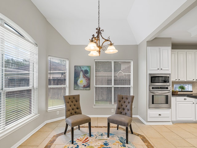 sitting room with light tile patterned floors, an inviting chandelier, and vaulted ceiling