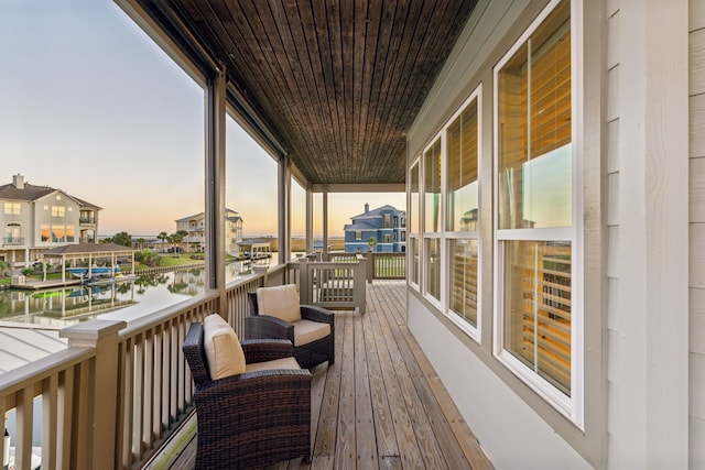 deck at dusk featuring a water view